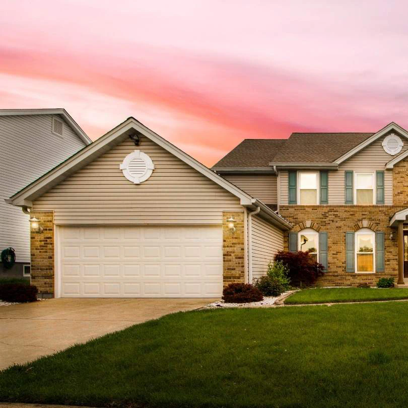 A home with a sectional garage door at sunset