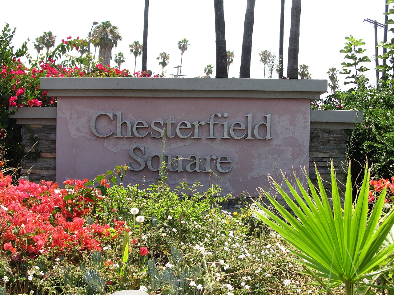 Chesterfield Square neighborhood monument surrounded by flowering landscaping.