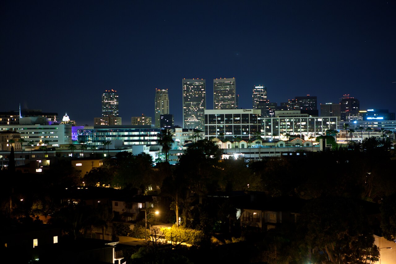 Nighttime view over Beverly Hills, with a distant skyline in the background.