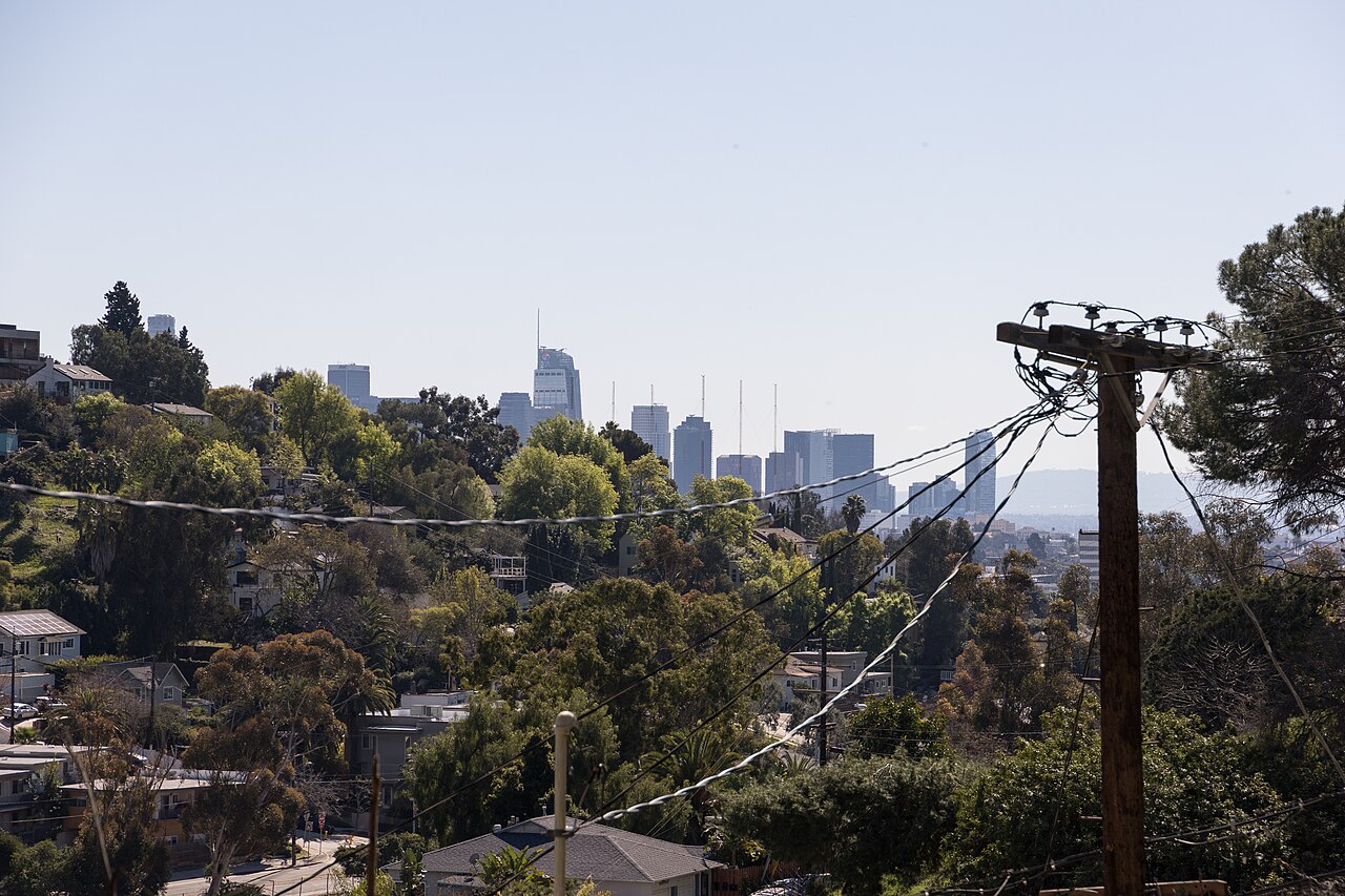 Hillside residential foreground and downtown skyline in distance.