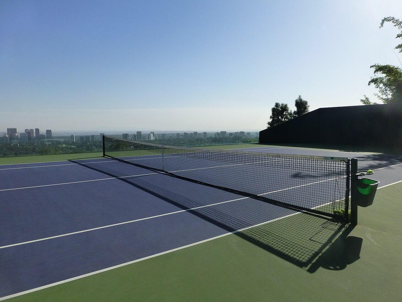 View across a tennis court toward Los Angeles from Beverly Crest.