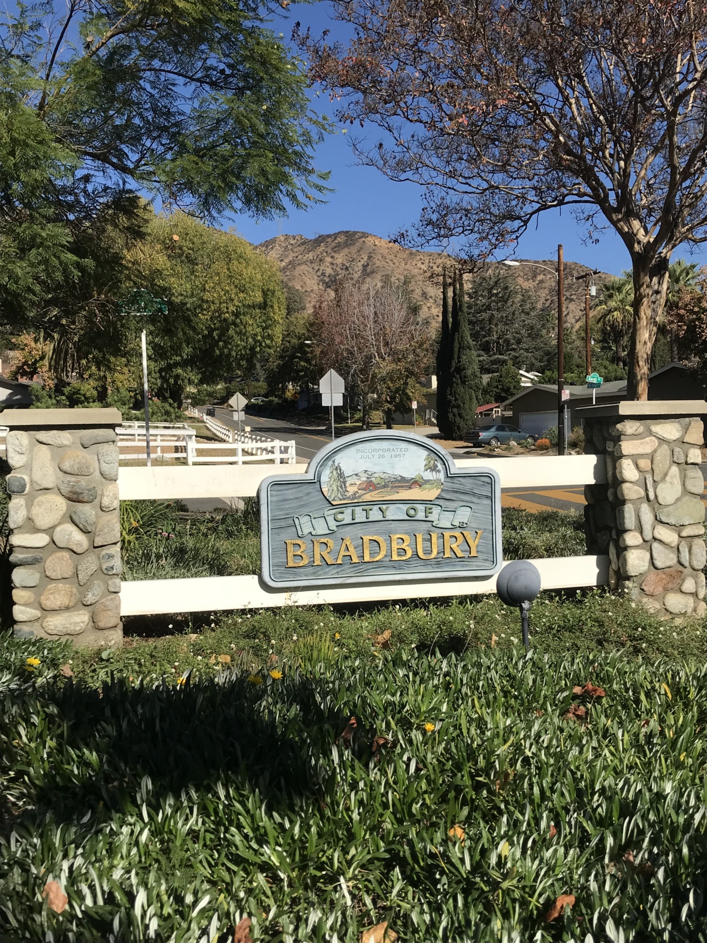 City of Bradbury sign framed by stone pillars and foothills.