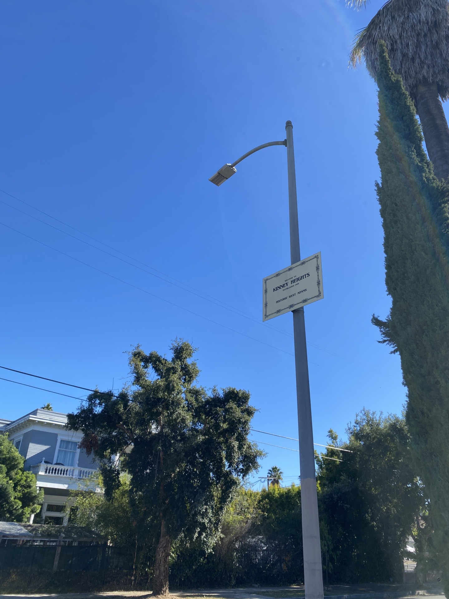 Kinney Heights neighborhood sign beside a tree-lined residential street.