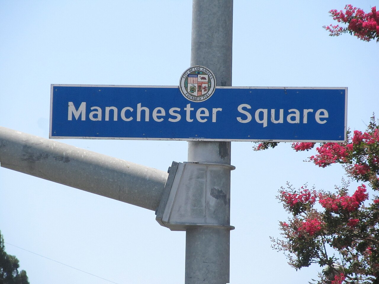 Manchester Square neighborhood sign with flowering trees.
