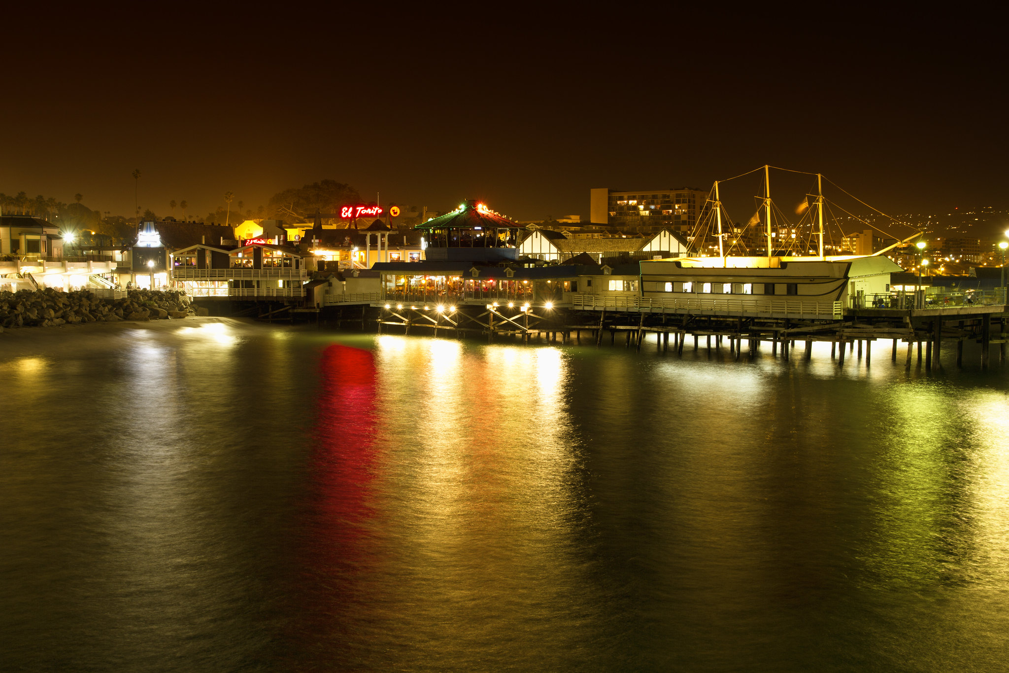 Illuminated restaurants along Redondo Beach Pier reflected in the water